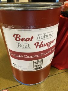 A large red barrel with a sign reading Beat Auburn Beat Hunger