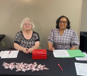 Betty Wedgeworth and Pamela Pruitt seated at registration table.